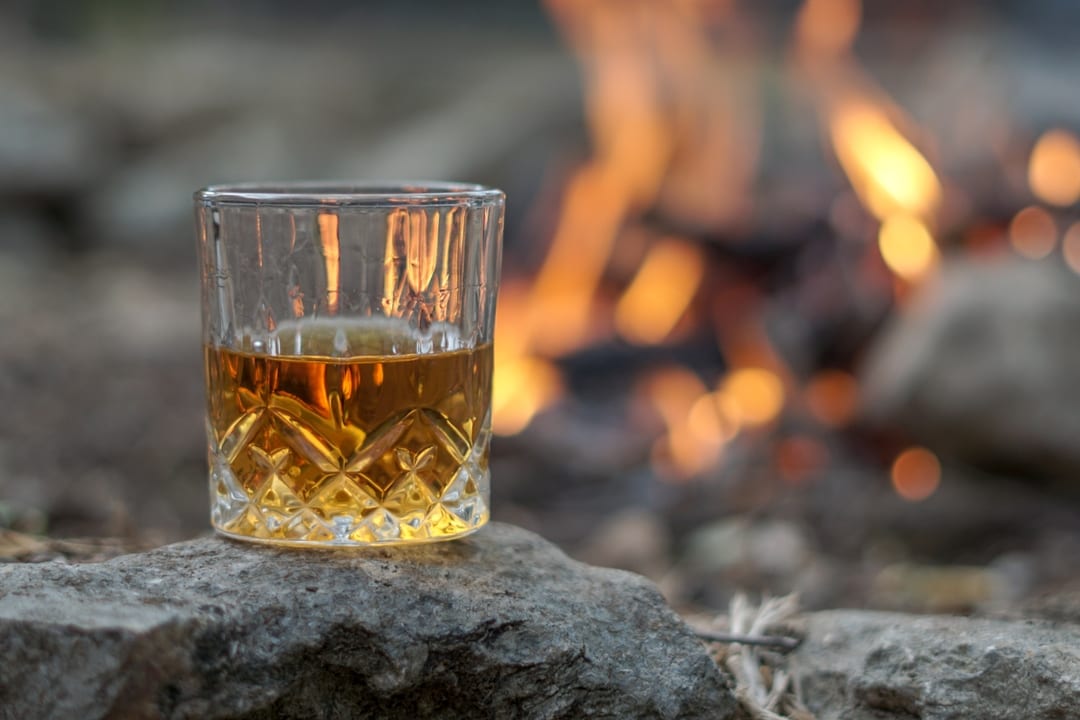 Glass of Irish Whiskey being served next to a fire